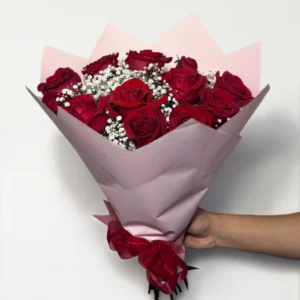Ramo de 12 rosas rojas con follaje envueltas en papel coreano coreano con moño rojo.