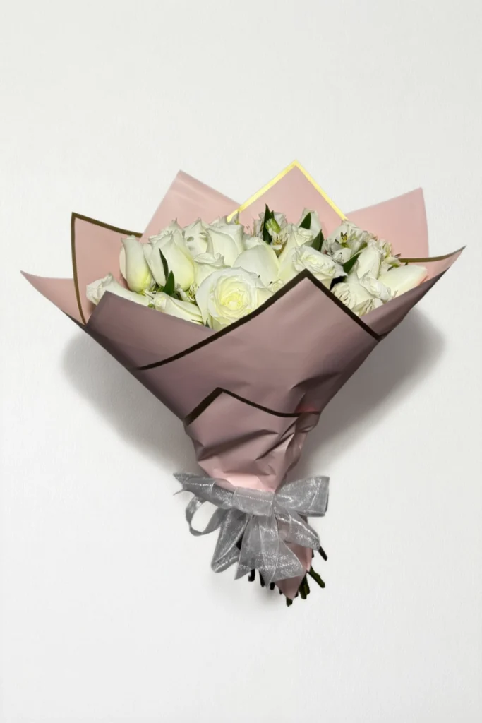 Ramo de 24 rosas blancas con follaje envueltas en papel coreano coreano con moño.