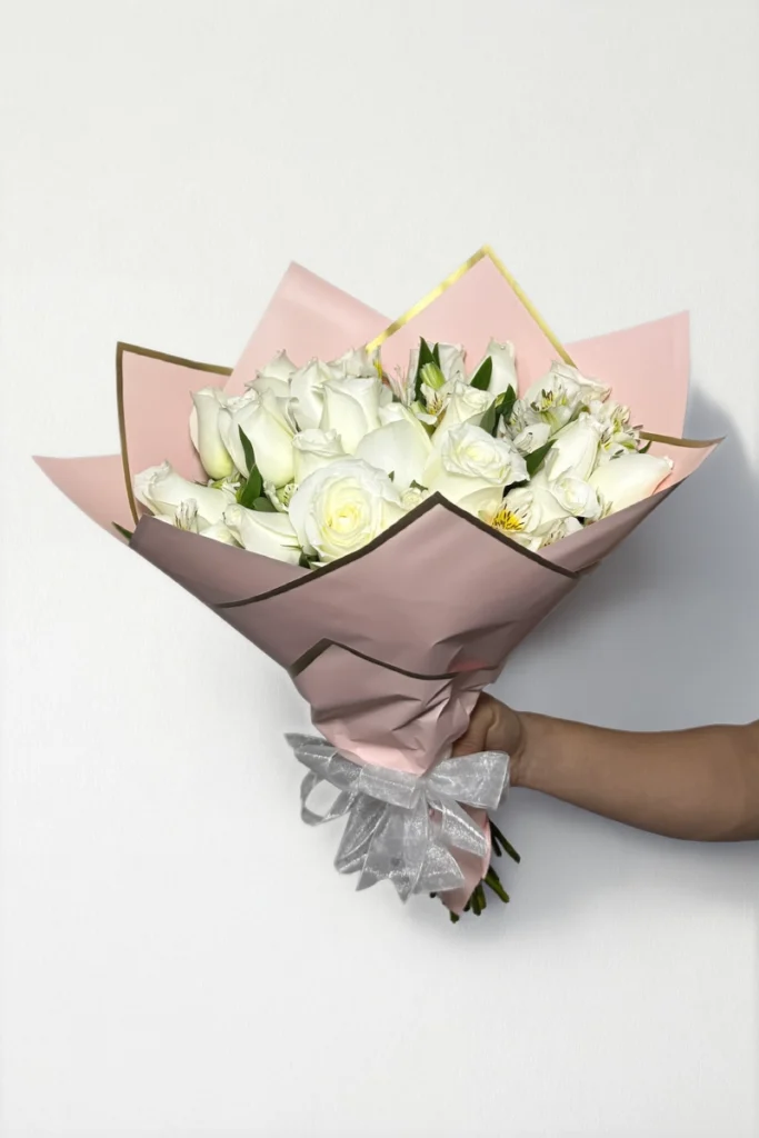 Ramo de 24 rosas blancas con follaje envueltas en papel coreano coreano con moño.