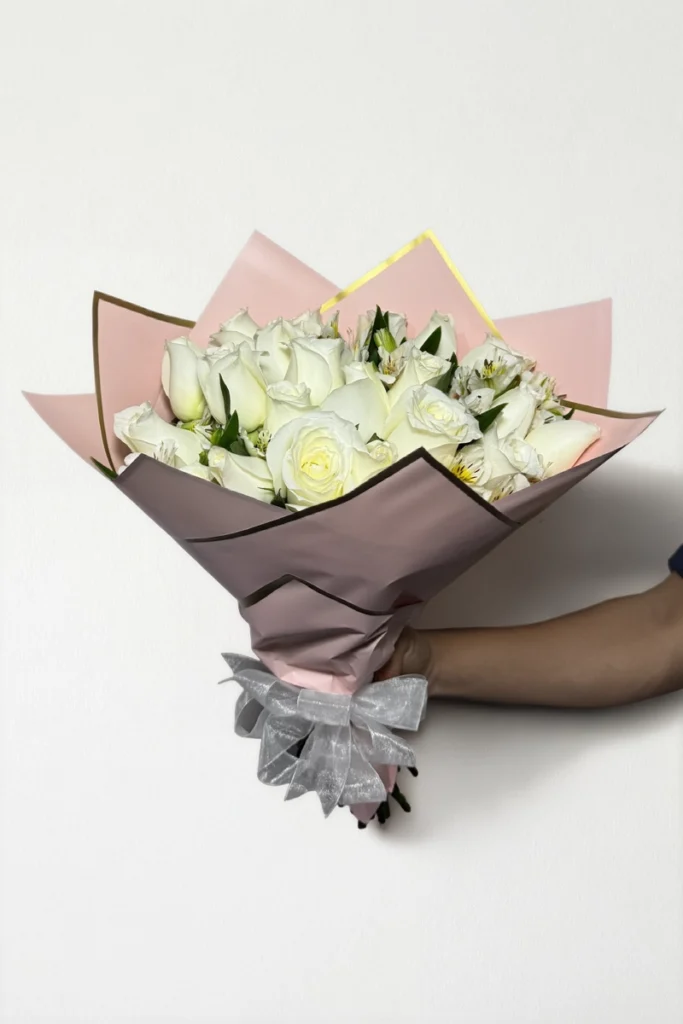 Ramo de 24 rosas blancas con follaje envueltas en papel coreano coreano con moño.