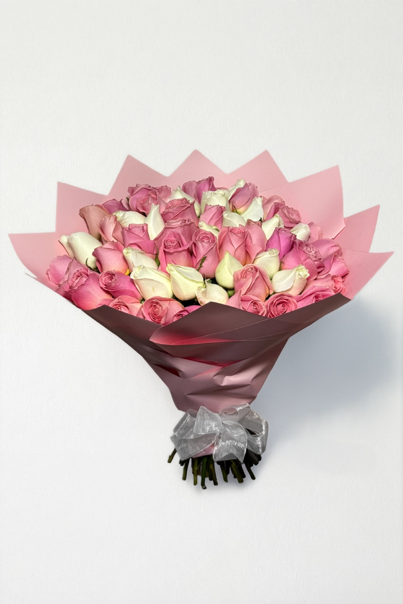 Ramo de 50 rosas blancas y rosas con follaje envueltas en papel coreano con moño.