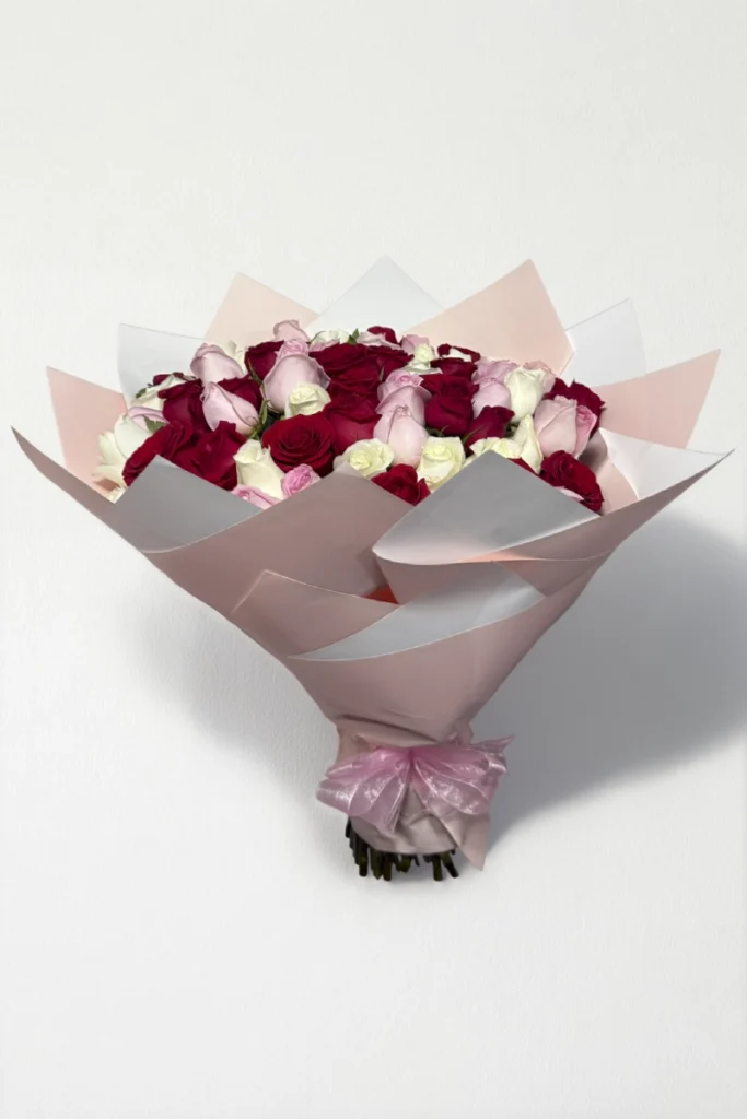 Ramo de 50 rosas rojas, rosas y blancas con follaje envueltas en papel coreano con moño.