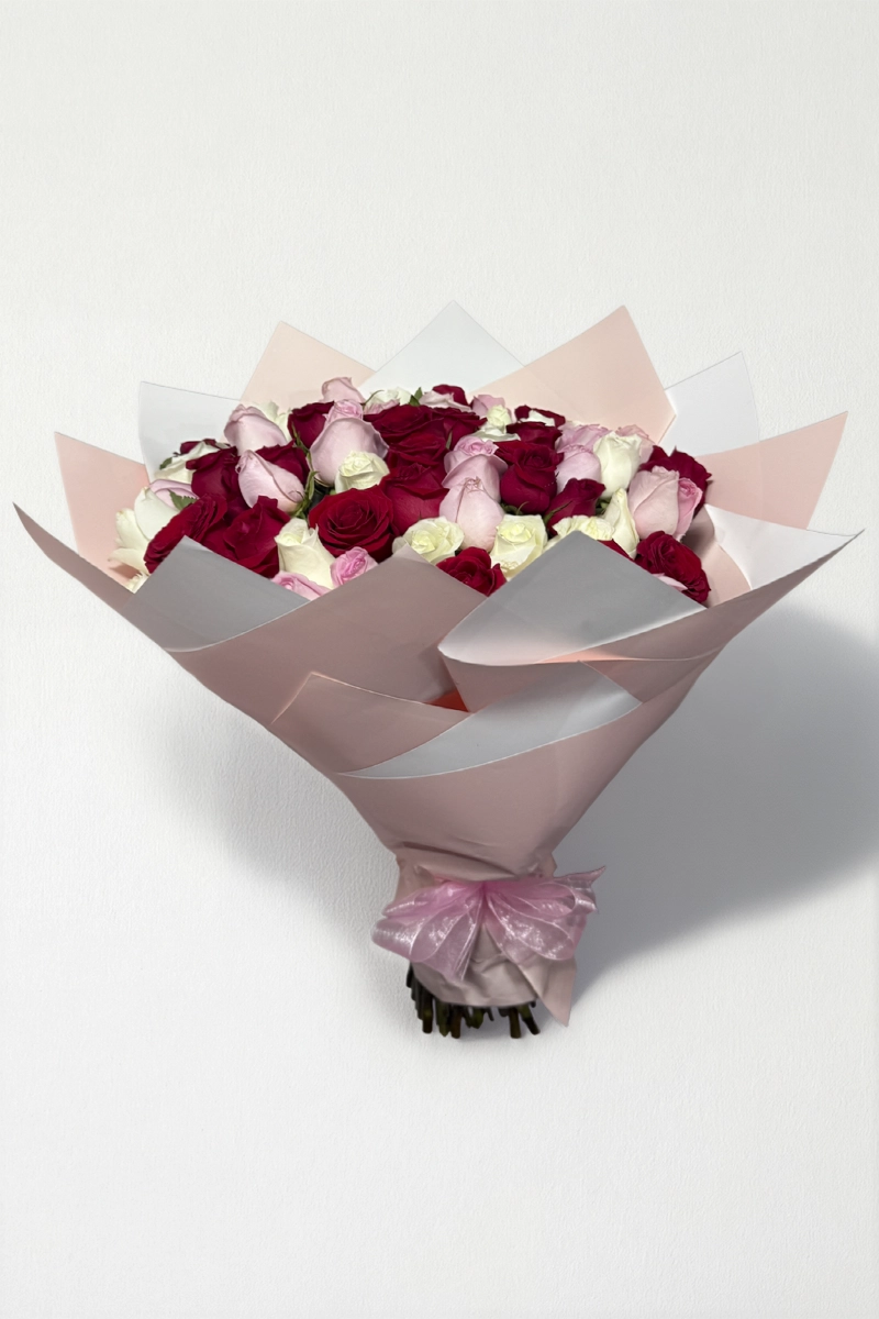 Ramo de 50 rosas rojas, rosas y blancas con follaje envueltas en papel coreano con moño.