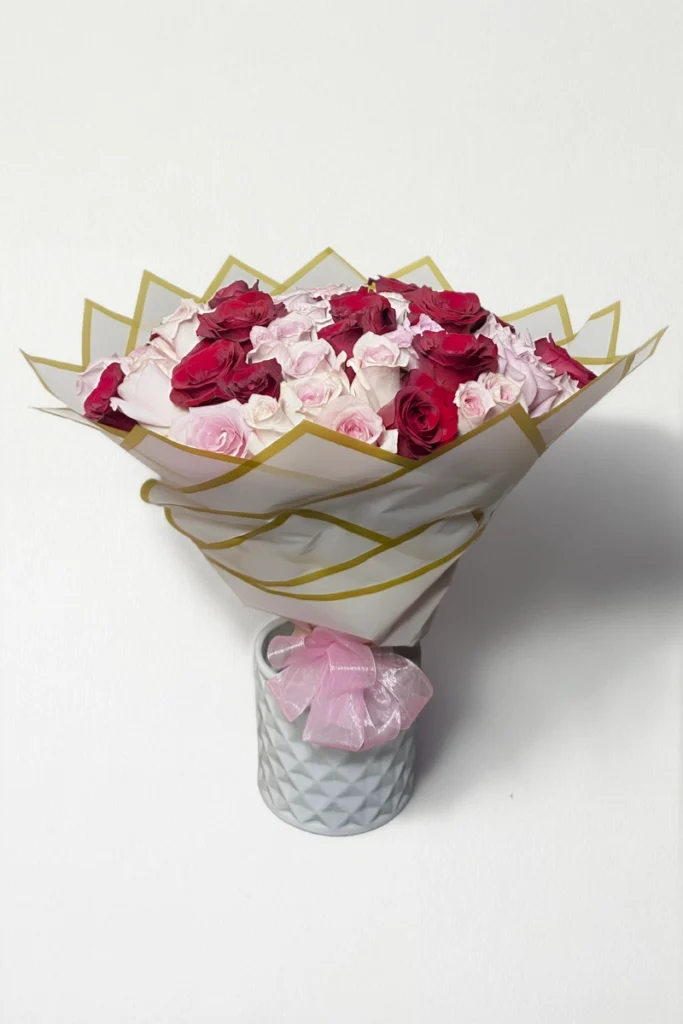 Ramo de 50 rosas rojas y rosas con follaje envueltas en papel coreano con moño.